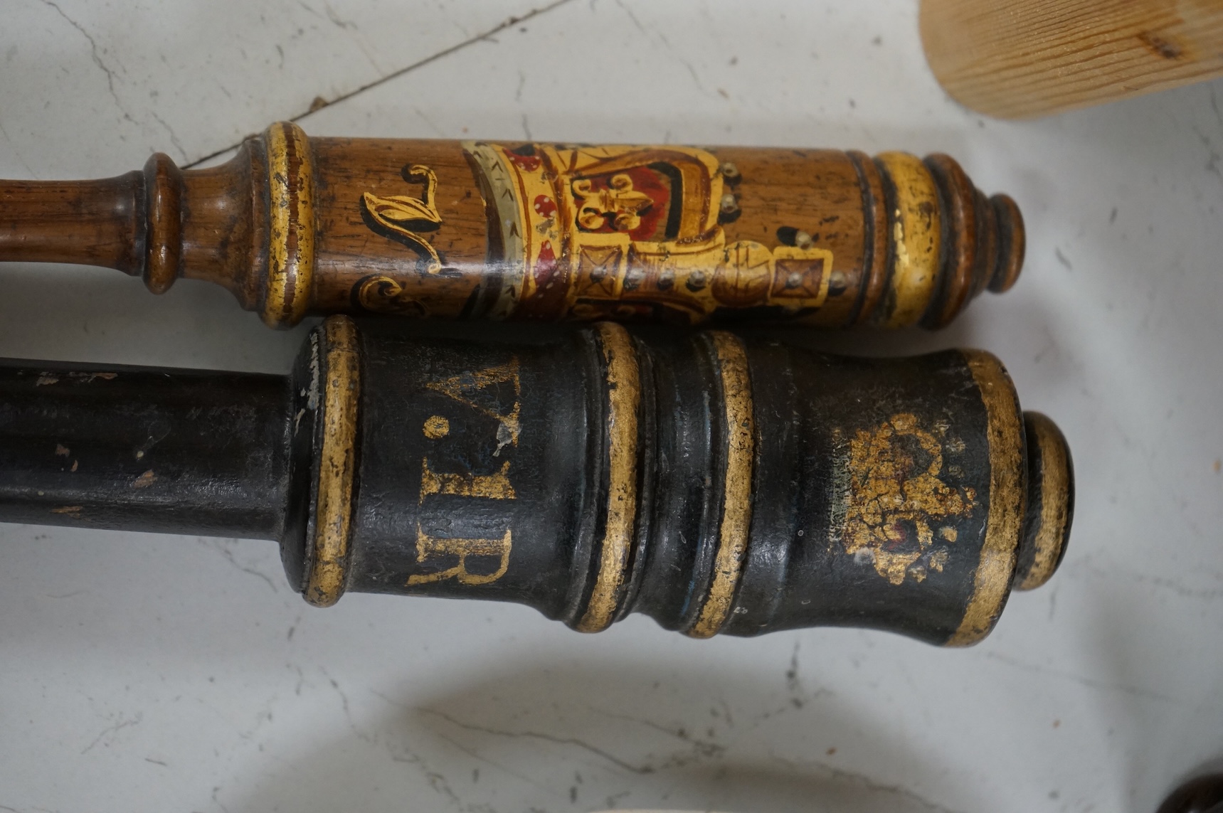 Two Victorian turned and painted wood tipstaffs, each painted with the Royal cypher, one inscribed ‘York’, largest 33cm in length
